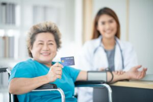 healthcare patient holding up a medical credit card - credit card processing for healthcare