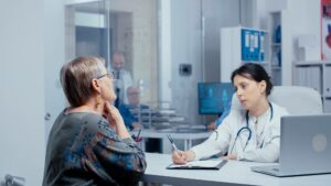doctor's office receptionist speaking with patient during healthcare revenue cycle