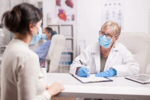 masked doctor following HIPAA while assessing a masked patient
