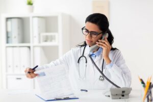 doctor on the phone updating a patient's chart containing PHI