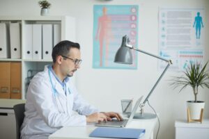 doctor typing on laptop to lookup CPT codes