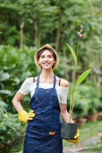 woman smiling holding plant in her landscaping business