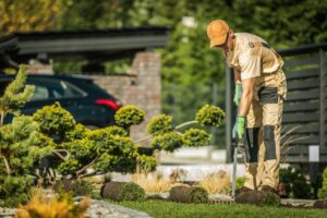 male landscaper performing gardening work for which he'll use a a landscaping invoice template to bill